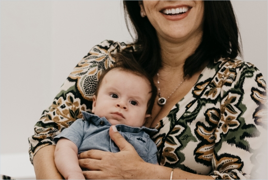 Mãe segurando seu bebê em uma consulta com a Dra. Aline Fajardo